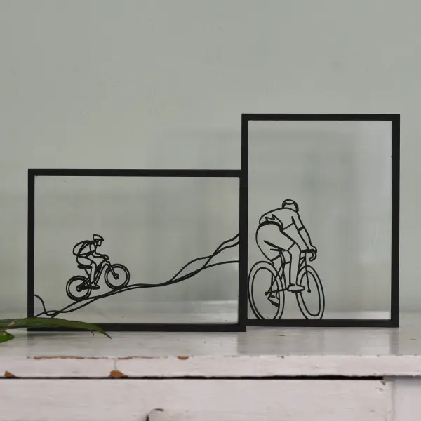 Minimalistisch kunstwerk met lijntekening van een fietser in houten lijst