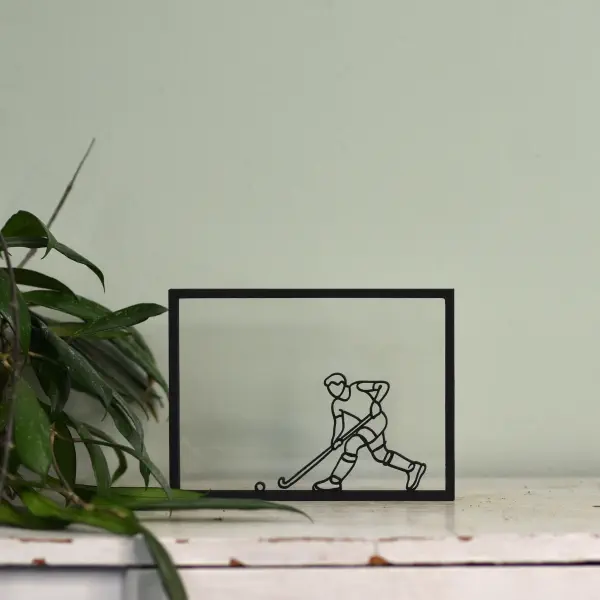 Houten floating frame met minimalistische lijntekening van een hockeyer
