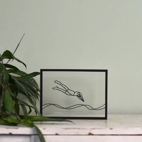 Houten floating frame met lijntekening van een zwemmer – minimalistische woondecoratie